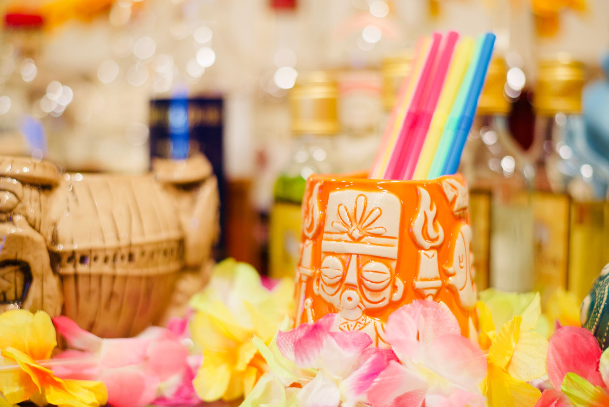 Hawaiian tiki bar with mugs, leis, and rum